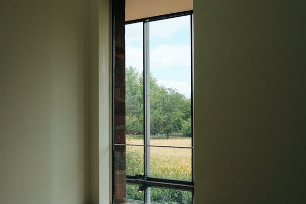 Empty, spacious studio with large windows and natural light.